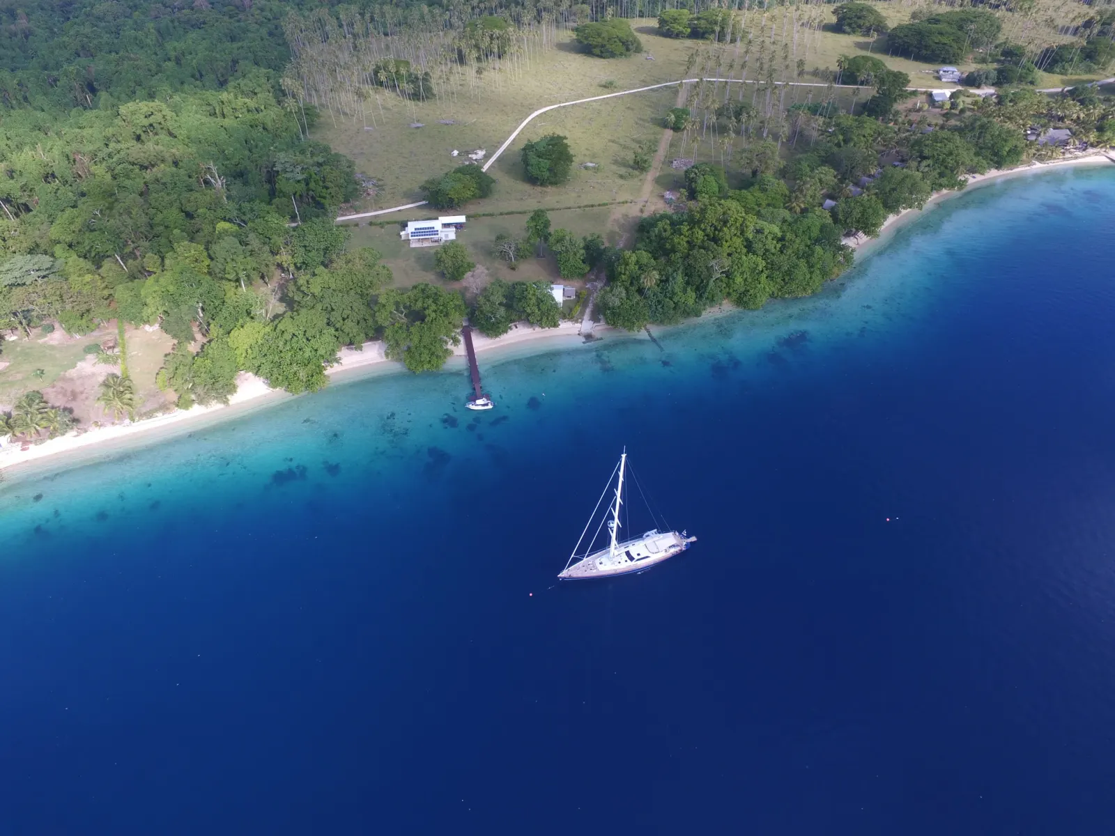 The shore of Aore Island with a yacht at anchor