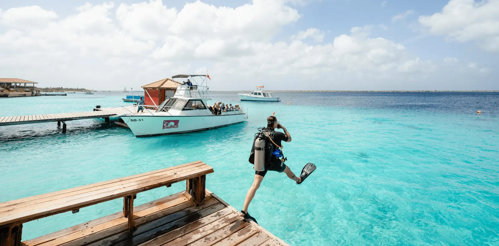 A diver stepping off the pier