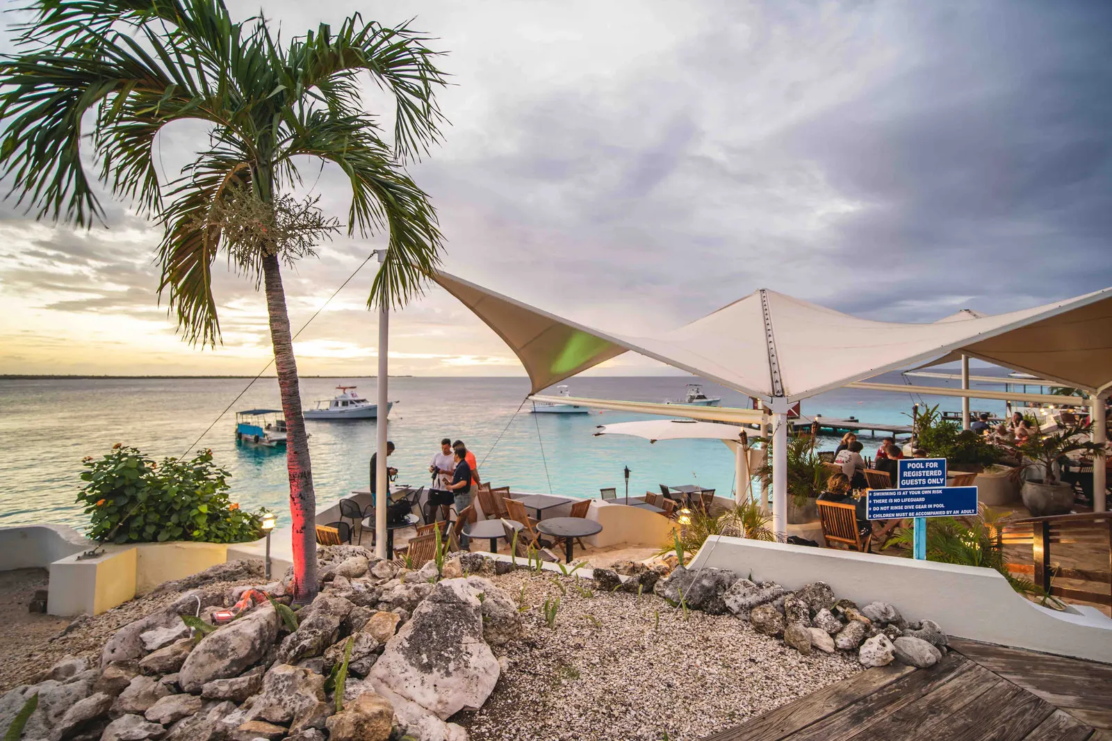 A terrace under sun sails by the water