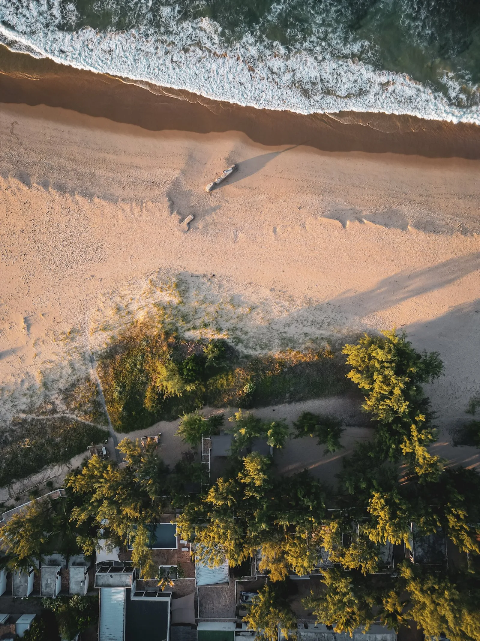Лодка на песке у кромки воды, вид сверху