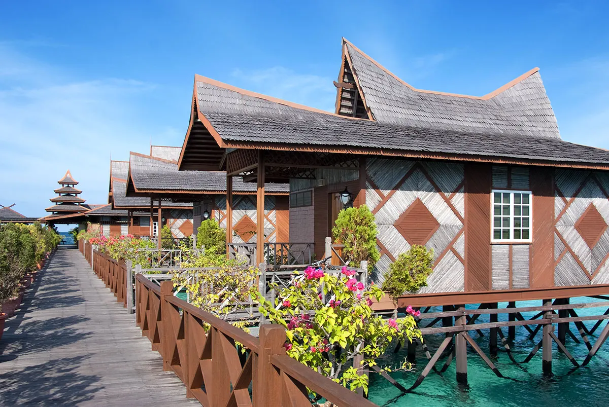 A row of bungalows and flowering shrubs on the walkway