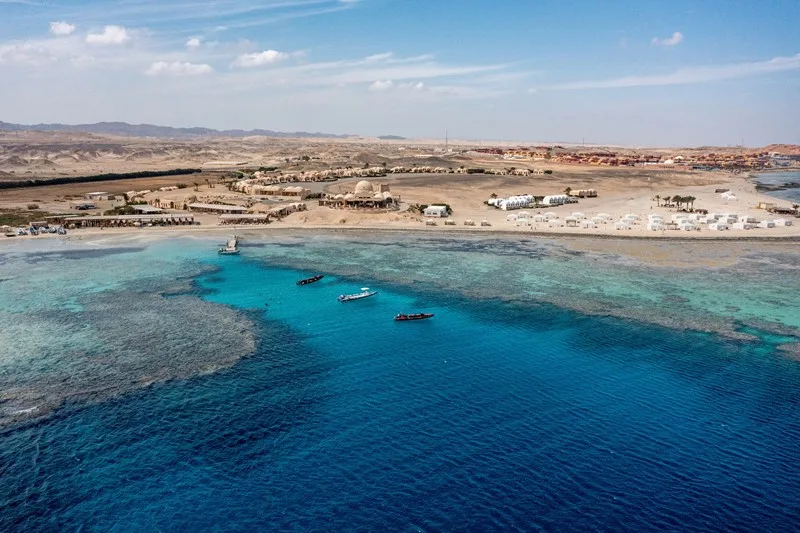 The village on the shore and the coral reef from above