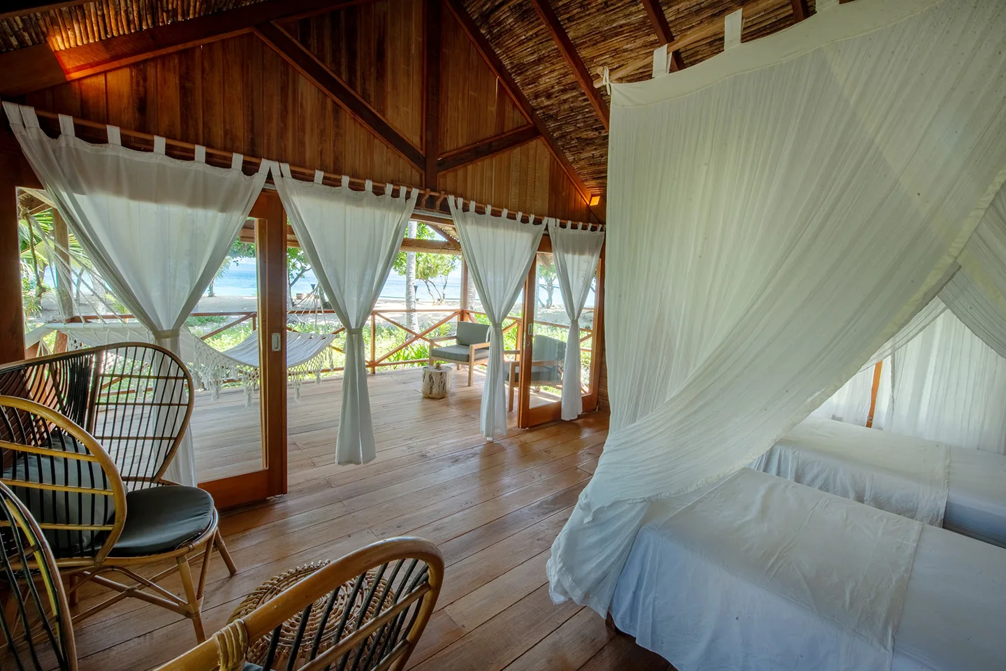Beach Cottage — спальня с плетеными креслами и выходом на веранду