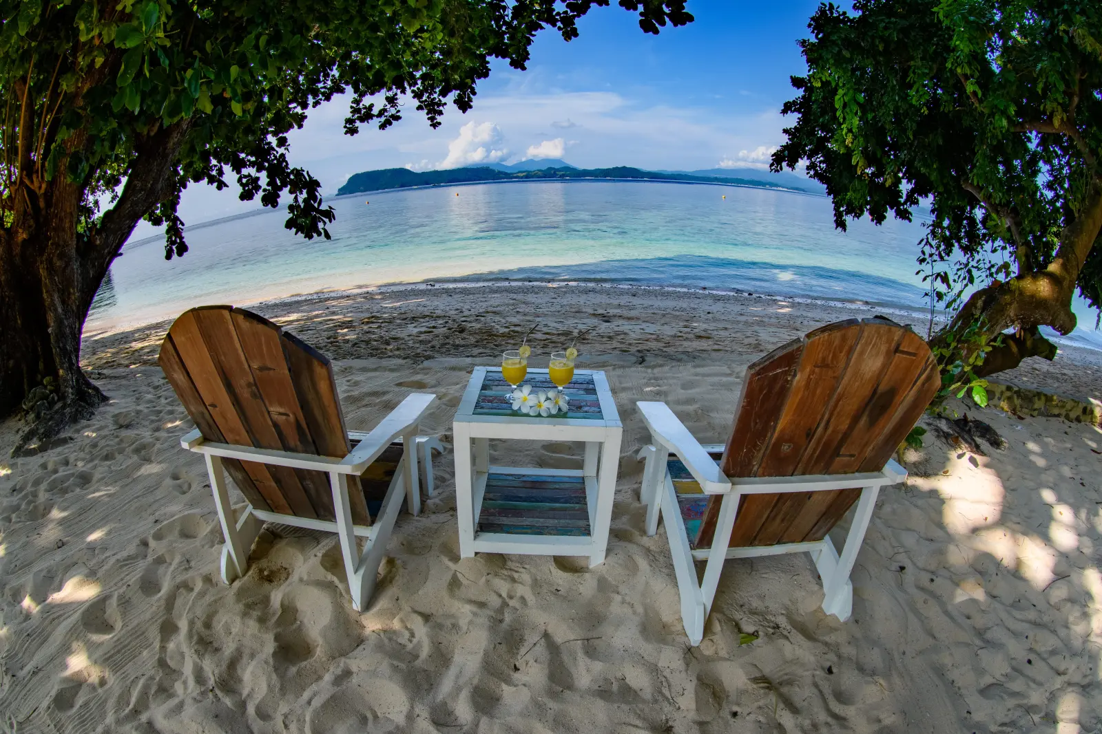 Table and chairs in the shade on the beach
