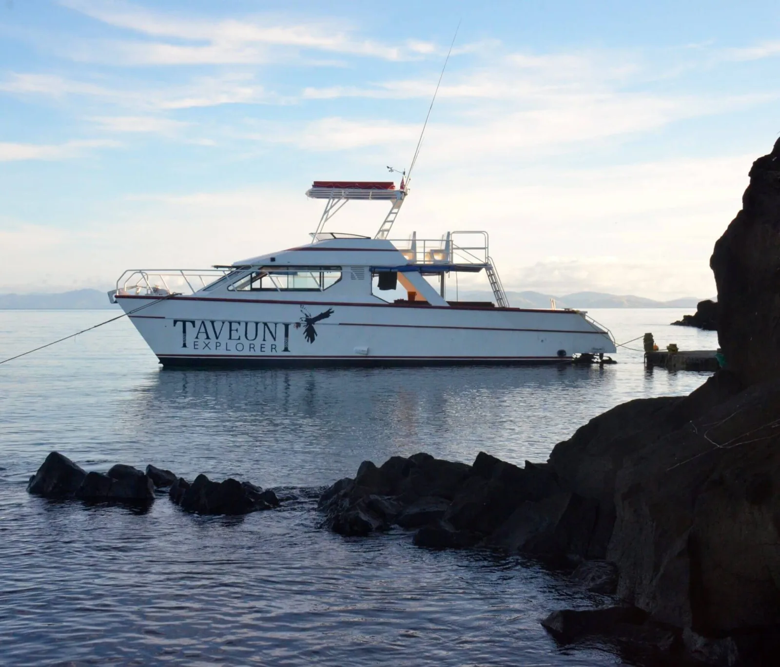 Катер Taveuni Explorer на якоре у скал