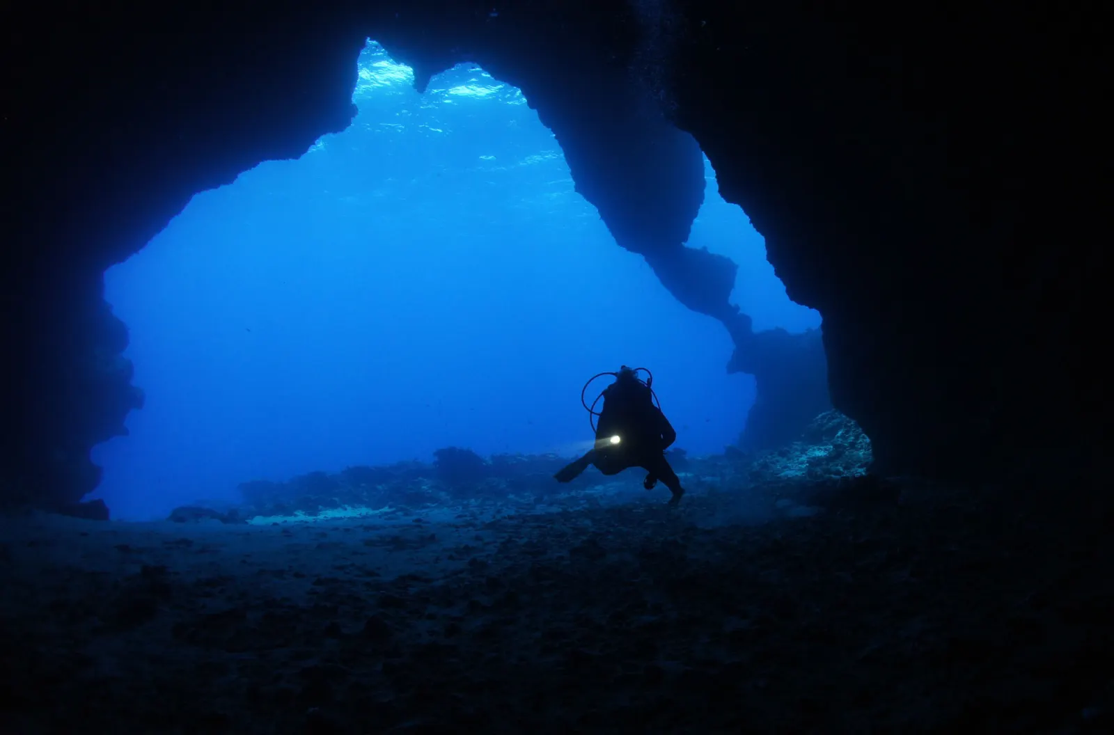 A diver at the mouth of a cave