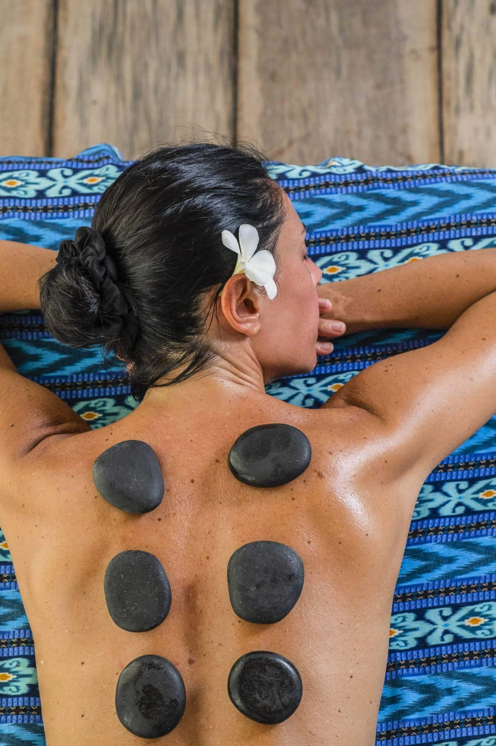 A spa guest with a frangipani flower