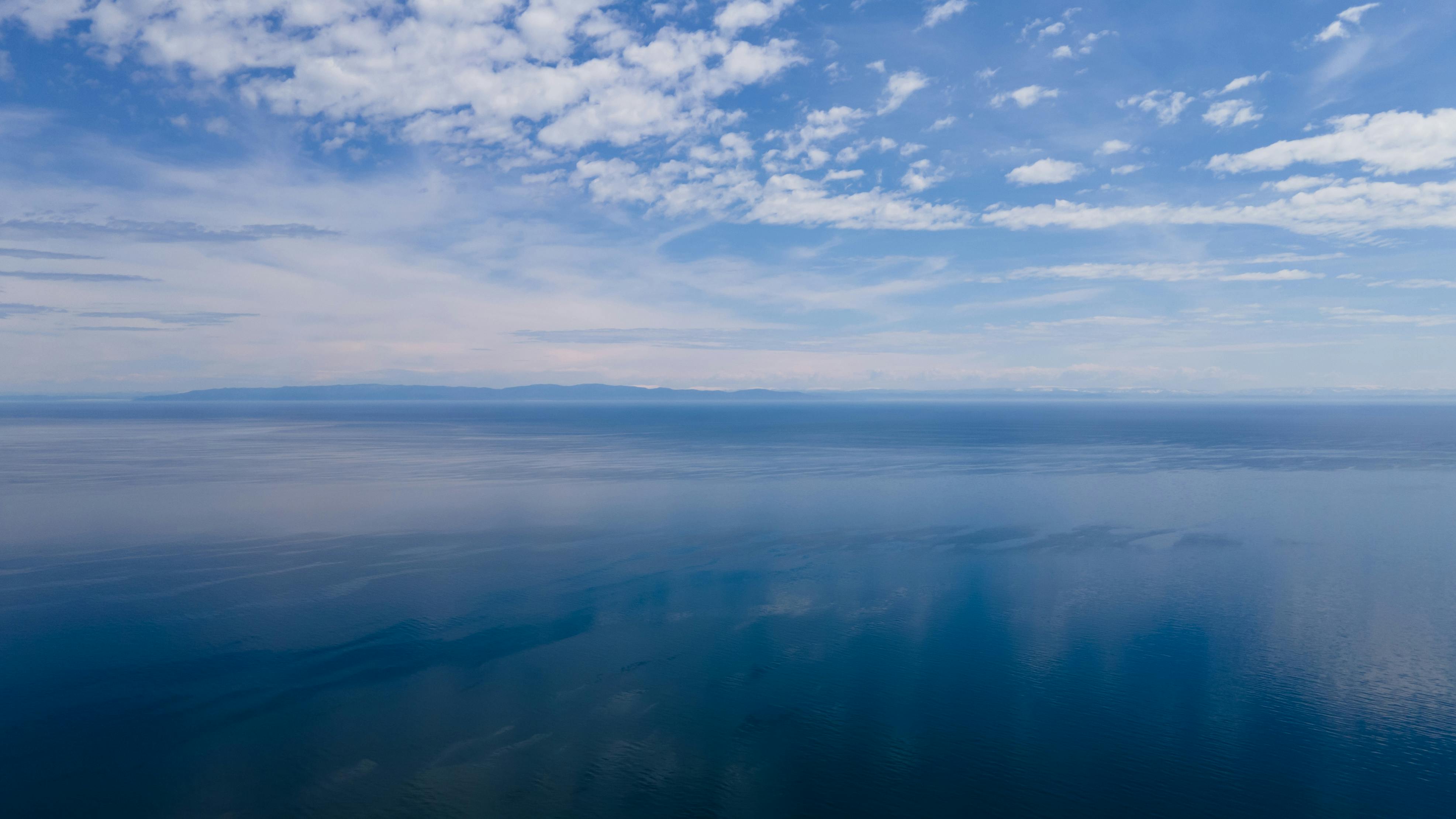 Бескрайняя гладь Байкала с высоты — облака отражаются в воде